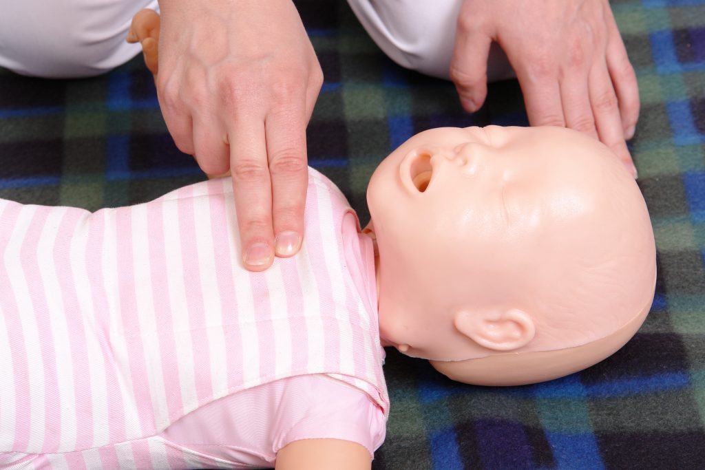 Eine Baby-Übungspuppe wird reanimiert.